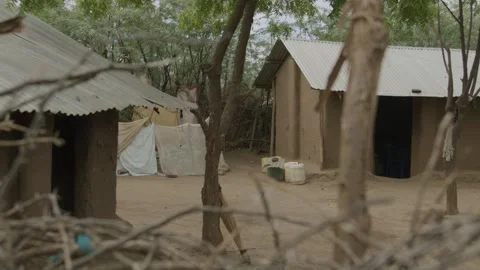 Panning Slow-mo Branches on foreground, Houses on background in Kakuma, Kenya Stock Footage 243684242