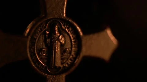 Panning soft-focus shot of a Saint Benedict rosary beside the candle Stock-Footage 163921012