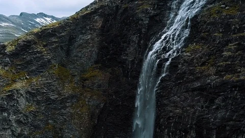Panning a stunning dramatic waterfall on a steep vertical cliff face with Stock Footage 99681287