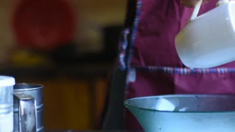 Panning style view of a woman's hands pouring liquid into a container Vídeos de archivo 151302165