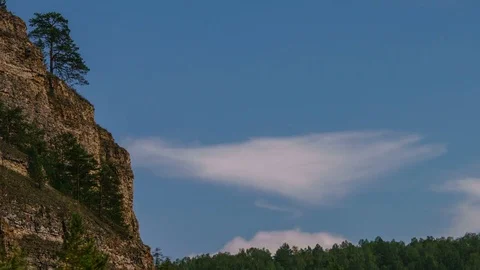 Panning summer day time-lapse of fast moving clouds over the mountain, valley Stock Footage 75869428