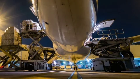 Panning time lapse cargo aircraft loading at twilight sky Stock Footage