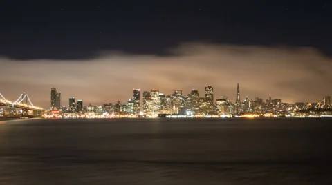 Panning time lapse of cloudy San Francisco shoreline and the bay bridge at night Stock Footage 43191664