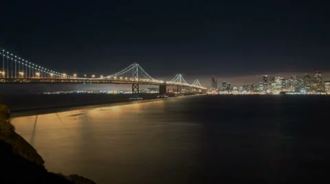 Panning time lapse of cloudy San Francisco shoreline and the bay bridge at night Stock Footage 43368368