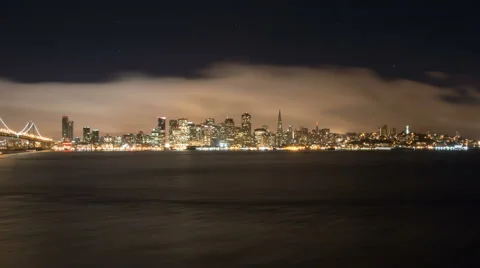 Panning time lapse of cloudy San Francisco shoreline and the bay bridge at night Stock Footage 43369047