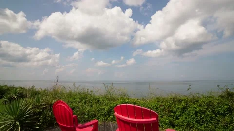 Panning Time-lapse of puffy clouds over the ocean in front of scenic patio Stock Footage 142237537