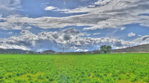 Panning time-lapse shot of thick clouds over green meadows in Utah with lens Stock Footage 52327774