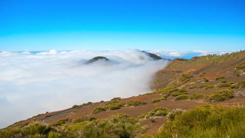 Panning timelapse from cloud waterfall to calm sea of clouds on volcanic slope, Stock-Footage 335765080