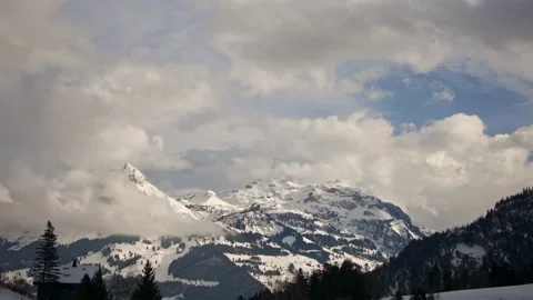 Panning timelapse of the clouds flying over white snowy peaks of the Alps Vidéo 231918644