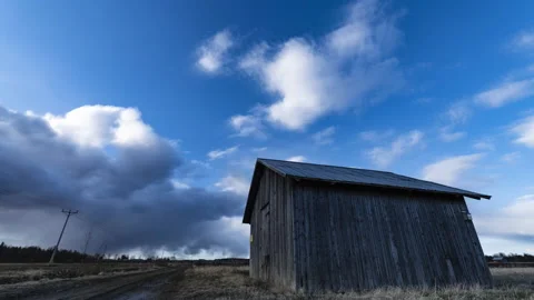 Panning timelapse video on dramatic clouds that move above standalone shed Vídeos de archivo 135763506