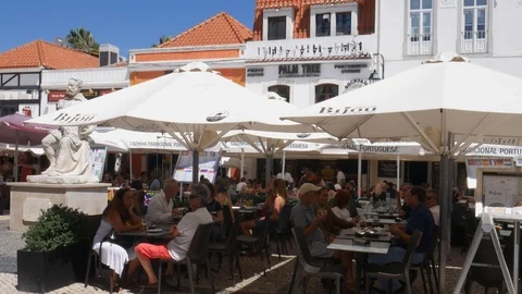 Panning of tourists at Largo Luis de Camoes with cafes and restaurants in Stock Footage 114438468