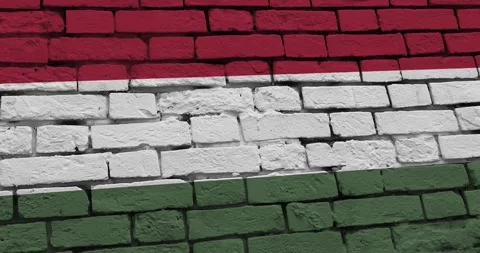 A panning video of a brick wall with the hungary flag 스톡 동영상 337428993