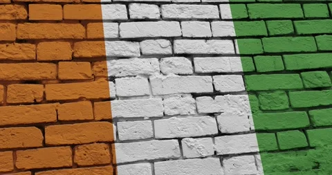 A panning video of a brick wall with the ivory coast flag Видео 337429275