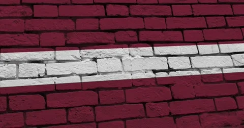A panning video of a brick wall with the latvia flag Video stock 337429599
