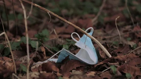 Panning video of a face mask decomposing in nature Stock Footage 208641638
