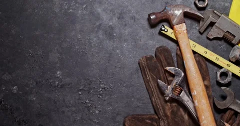 Panning video of old, worn, and dirty work tools including a hammer, tape m.. Stock Footage 282473487
