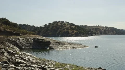 Panning view across the Tagus River from a rocky shore in Monfrague National Stock Footage 339460946