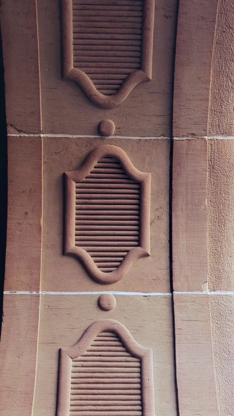 Panning View of an Ancient Carved Red Sandstone Wall Facade With Louver Patterns Stock Footage 332569824
