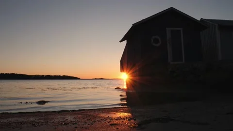 Panning view of bath cabin on a beach at sunset, beautiful sun flare Stock Footage 150432595