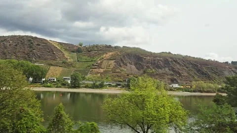 Panning view of a calm river and steep rocky hills from a moving train window Stock Footage 346654040