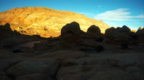 Panning view of cliffs lit up by the sun near the Wave. Video stock 54055532