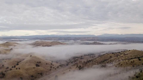 Panning View of Fog and Clouds in Dry Grass Hills with Snow Crapped Mountains Stock-Footage 123439253