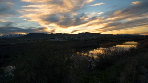 Panning view of a golden sunset reflecting off the river's surface Stock Footage