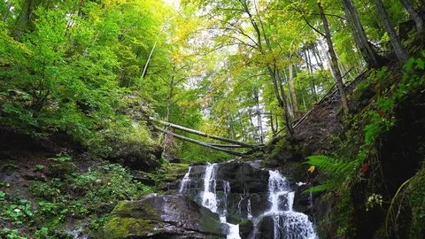 Panning view of a mountain waterfall in summer forest Stock Footage 119961689