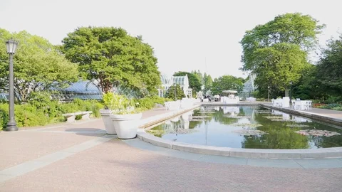 Panning view of a pool in a park with some people in background Stock Footage 114029287