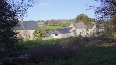 Panning view of some quaint cottages in the historic Cotswolds village of Stock Footage 143685558