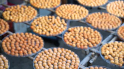 Panning view of sun exposuring dried persimmon making process in sieves in au Stock Footage 142416551
