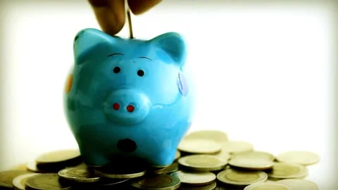 Panning view of unrecognizable person putting coins into a piggybank investme Stock Footage 265935776