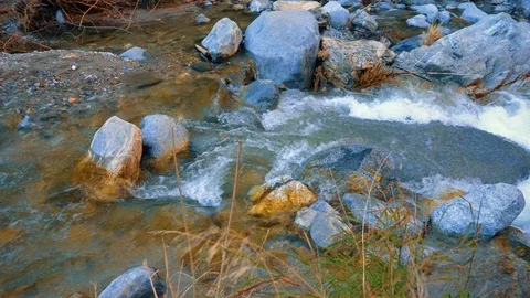 Panning. Water falling down the rocks in a mountain river. Big rock in water Video stock 105647291
