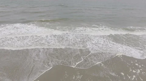 Panning from waves crashing on beach to clouds building in the distance. Stock Footage 68812966