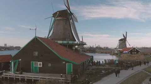Panning up on a windmill in the foreground in a typical Dutch landscape Stock Footage 99318173