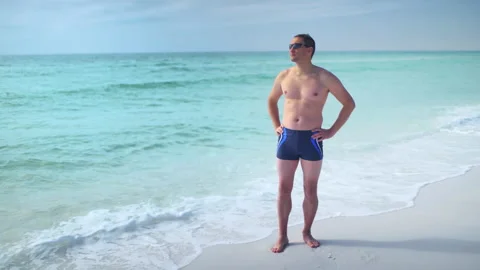 Panning young man standing at ocean sea shore coast in Seaside Florida Stock Footage 161852550