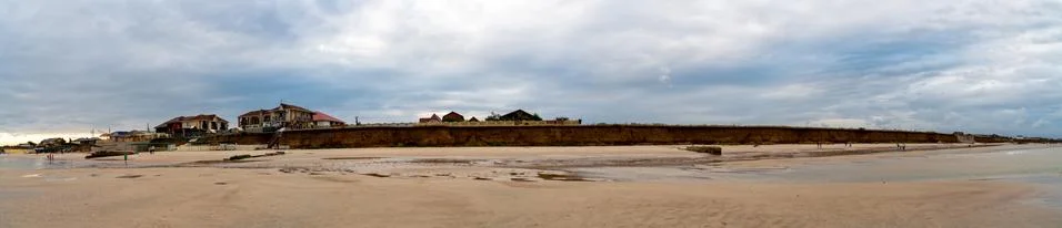 Pano - dramatic clouds float on the coast of the blue sea Stock Photos