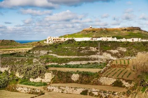 Panoram view on fields and lighthouse on the top of mountain. Gozo island, Ma Stock Photos