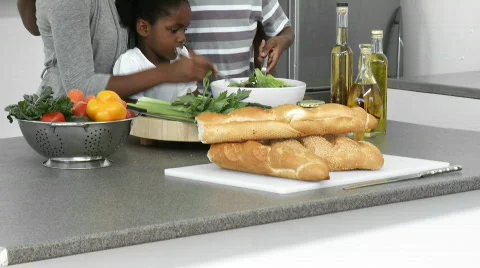 Panorama of Afro-American family cooking a salad at home Stock Footage