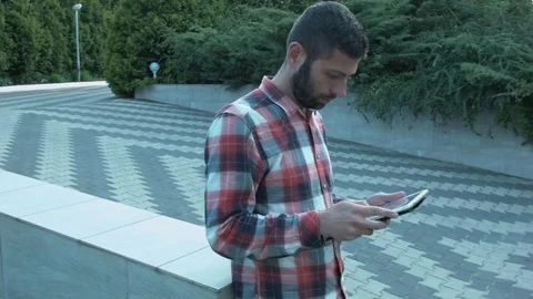 Panorama around a man with a tablet in his hands in the middle of the park Stock Footage 75722827