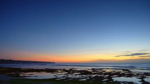Panorama of a beach after sunset with dark blue water and sky and waves Video stock 114820377