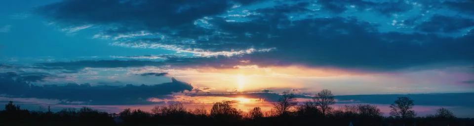 Panorama of a beautiful sunset with clouds Stock Photos
