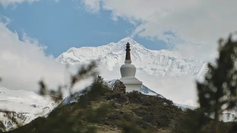 Panorama, buddhists stupa pinnacle touch a white glacial mountain peak in clouds Stock Footage 127088075