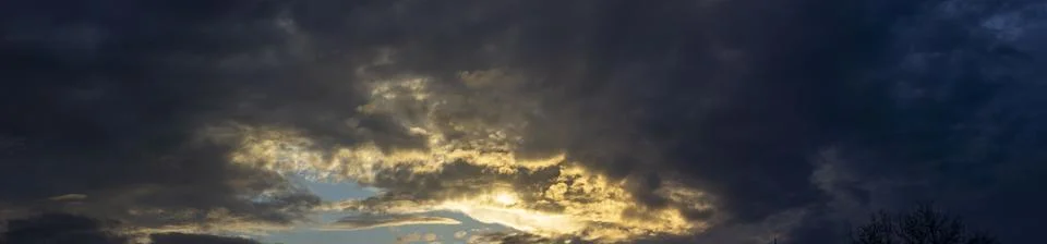 Panorama of cloudy sky with sun rays. Stock Photos