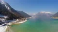 Panorama of deep blue lake at snowy mountains bottom, mirror-like water surface 4k or 4k+ Resolution