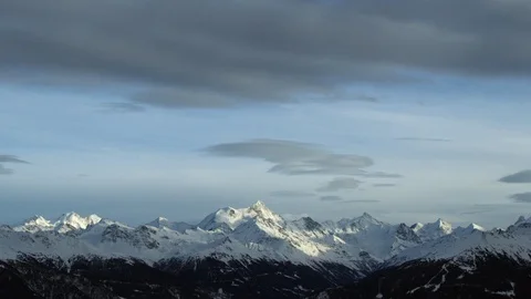 Panorama of dramatic clouds passing over sky above snow covered Swiss mountains Stock Footage 129099306