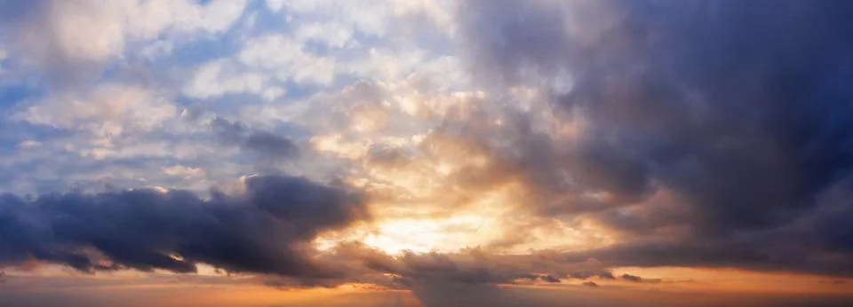 Panorama of dramatic cloudy sky at sunset. Stock Photos