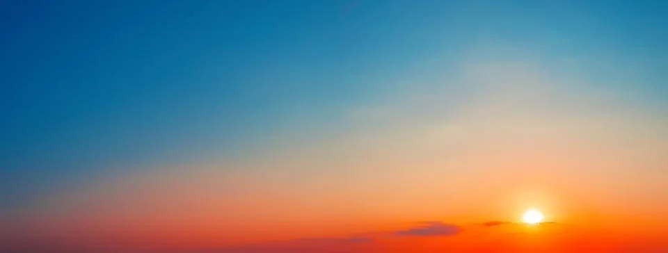 Panorama of dramatic sunset sky with setting sun Stock Photos