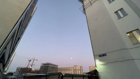 Panorama from evening sky down to construction site. Full moon over city Stock Footage 170696957