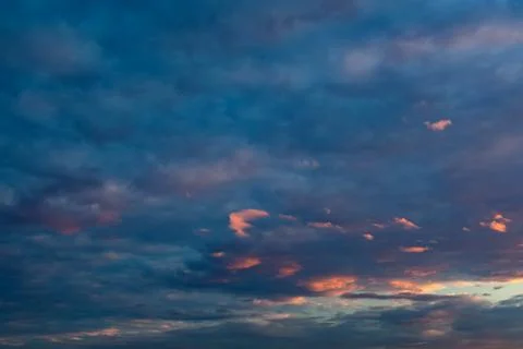 Panorama of the evening sky with dramatic orange, purple and dark blue clouds Stock Photos